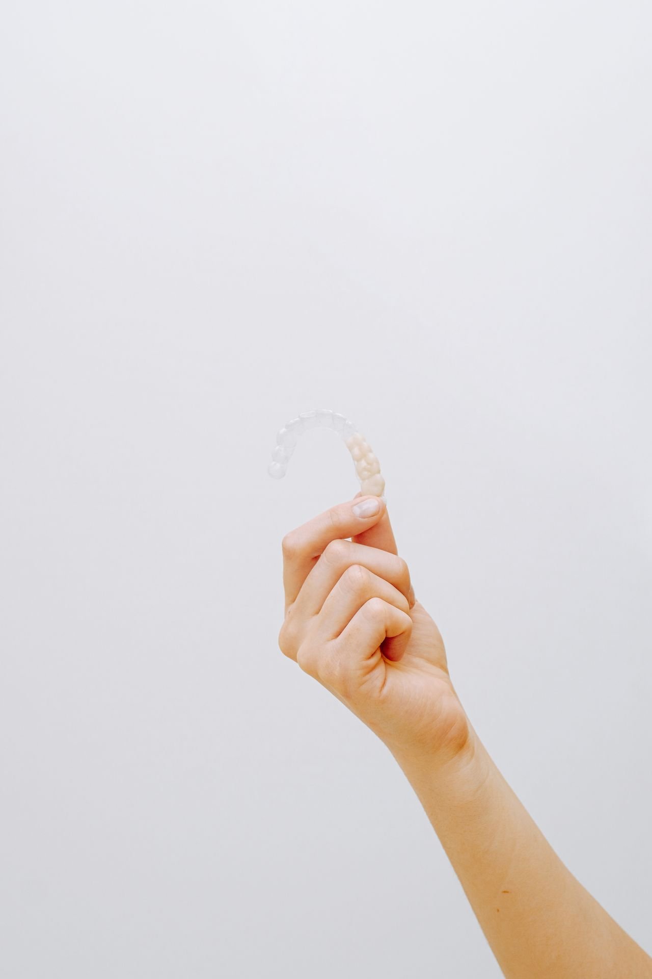 Hand holding a clear aligner tray