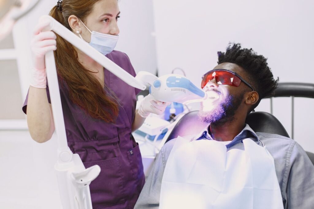 Dentist performing professional teeth whitening on a patient